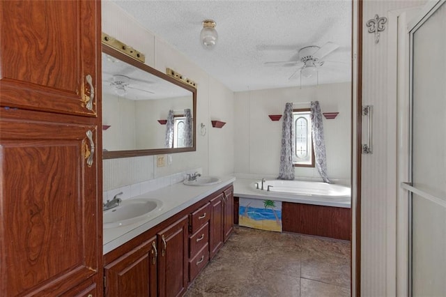 bathroom with a ceiling fan, a sink, and a textured ceiling