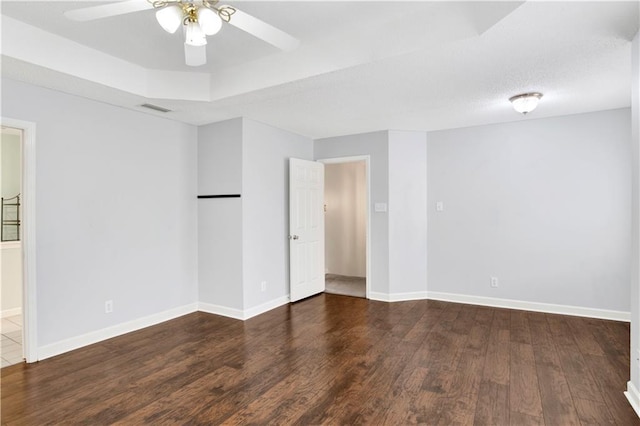 empty room with ceiling fan and dark hardwood / wood-style flooring