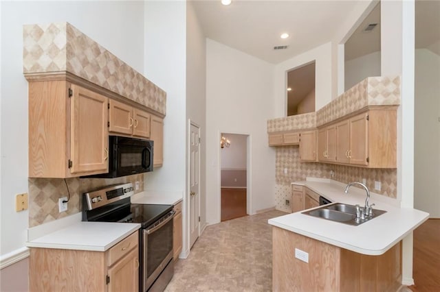 1056 Cross Gates Pl, Mobile, AL 36609 - kitchen with stainless steel electric range, black microwave, a peninsula, tasteful backsplash, and light countertops