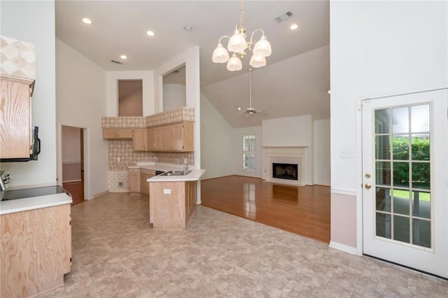 1056 Cross Gates Pl, Mobile, AL 36609 - kitchen featuring high vaulted ceiling, light brown cabinets, a chandelier, range, and a peninsula