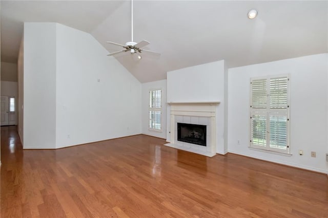 1056 Cross Gates Pl, Mobile, AL 36609 - unfurnished living room featuring healthy amount of natural light, ceiling fan, wood finished floors, a tiled fireplace, and high vaulted ceiling