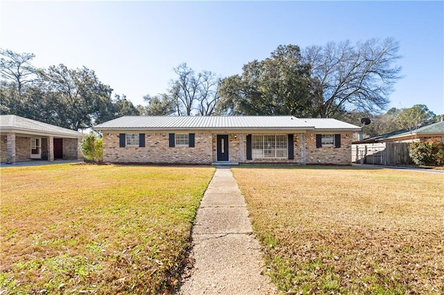 single story home featuring a front yard, brick siding, and fence