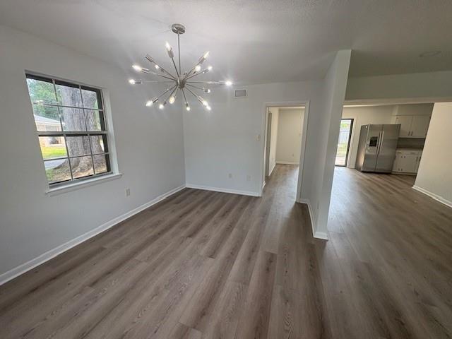 709 Oak Field Dr, Mobile, AL 36609 - unfurnished living room with a chandelier, dark wood-style flooring, and baseboards