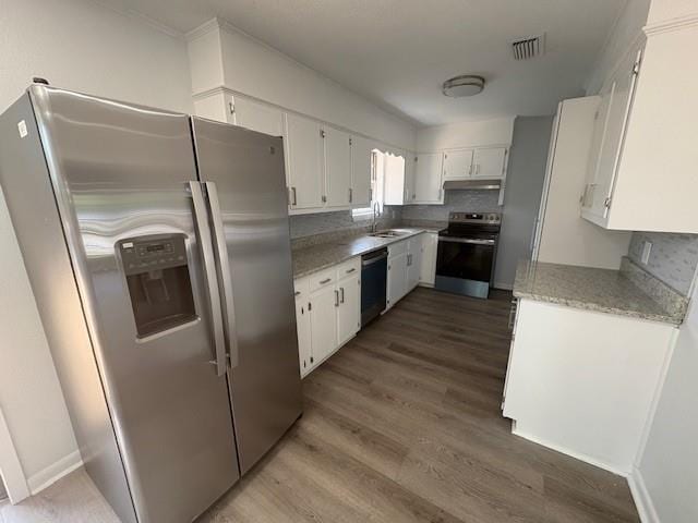 709 Oak Field Dr, Mobile, AL 36609 - kitchen with appliances with stainless steel finishes, under cabinet range hood, dark wood-type flooring, white cabinets, and light stone countertops