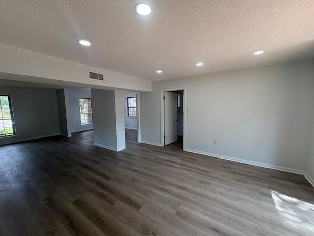 709 Oak Field Dr, Mobile, AL 36609 - empty room with a textured ceiling, plenty of natural light, baseboards, dark wood-style flooring, and recessed lighting