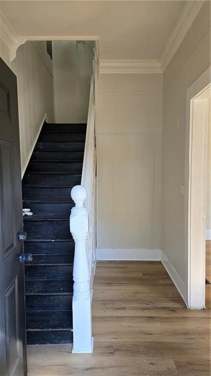 stairs featuring crown molding and wood-type flooring