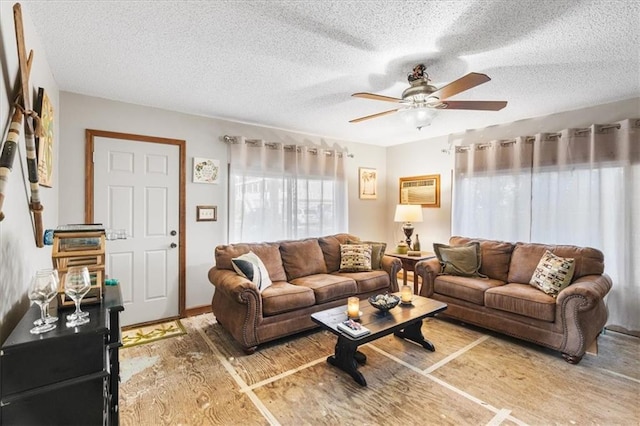 living room featuring a textured ceiling, an AC wall unit, and ceiling fan