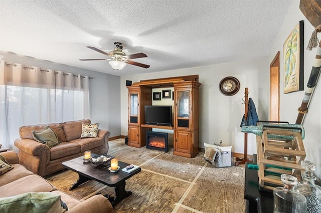 living room featuring ceiling fan and a textured ceiling