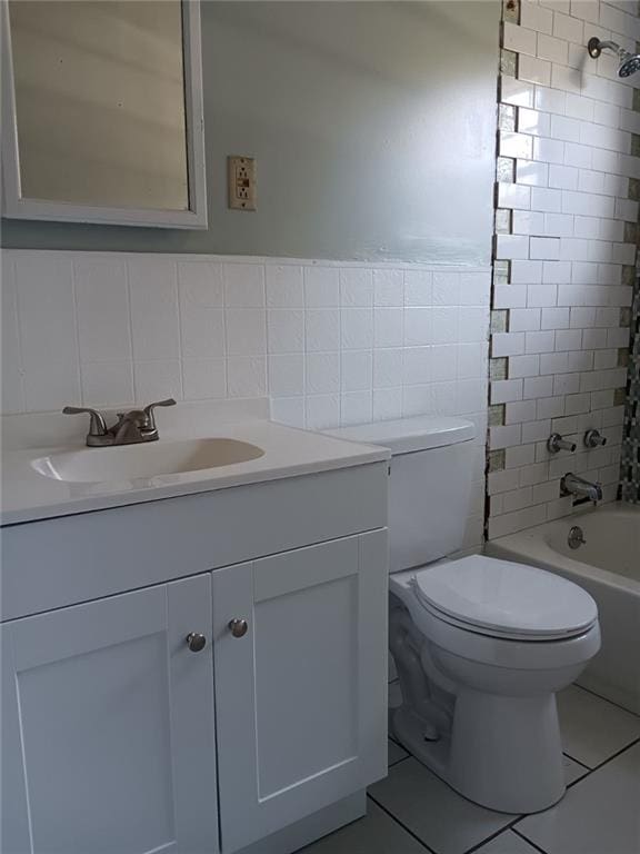 full bathroom with toilet, shower / bath combo with shower curtain, tile walls, vanity, and tile patterned flooring