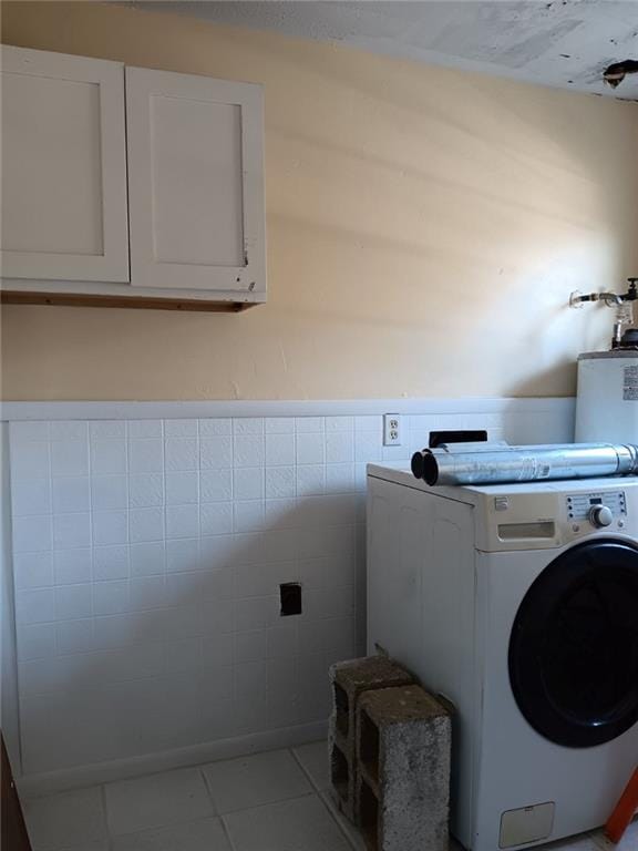 laundry room featuring washer / dryer, cabinets, tile walls, and light tile patterned floors