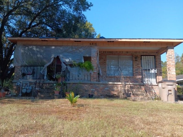 view of front facade with a front yard and a porch