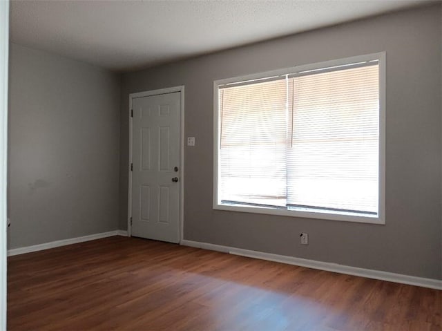 unfurnished room with dark hardwood / wood-style floors