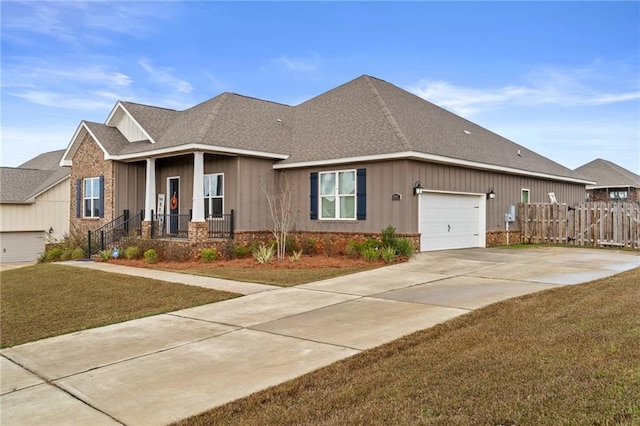 view of front of house with driveway, a shingled roof, fence, an attached garage, and a front yard