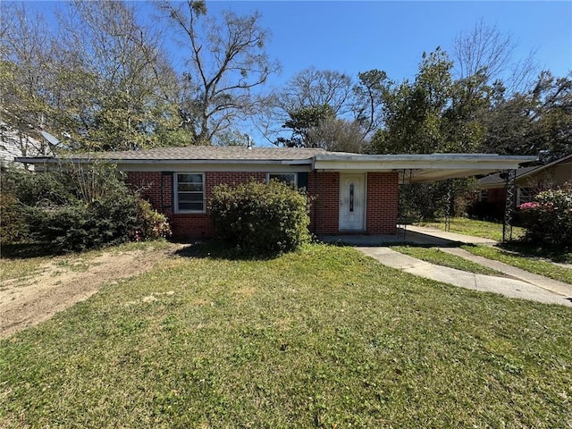 ranch-style house with brick siding, an attached carport, driveway, and a front lawn