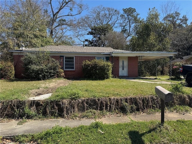 ranch-style home featuring a carport, brick siding, and a front yard