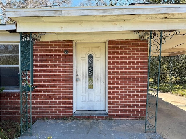 view of exterior entry with brick siding