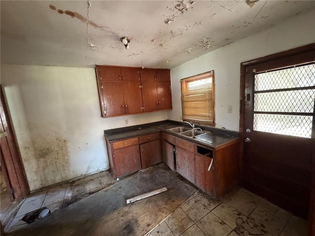 kitchen featuring a sink, dark countertops, and brown cabinetry