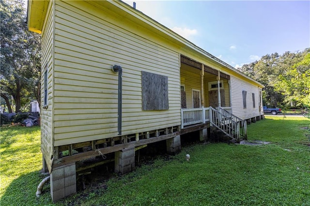 view of property exterior with a lawn and a porch