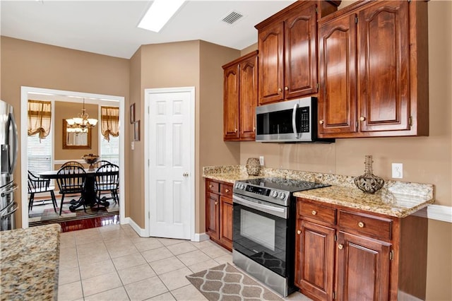 kitchen featuring light stone countertops, stainless steel appliances, a chandelier, and visible vents