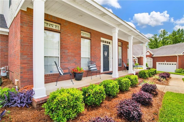 doorway to property featuring covered porch and brick siding