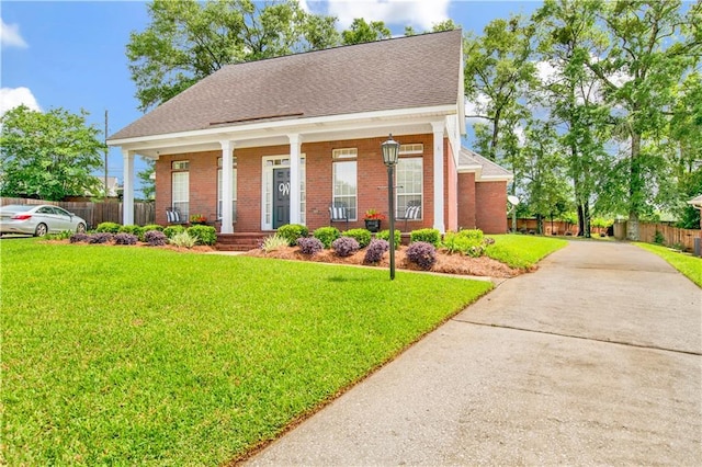 view of front of house with fence, a porch, driveway, and brick siding