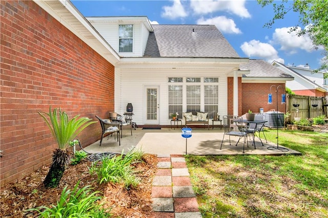 back of house with fence, brick siding, a shingled roof, a patio area, and central air condition unit