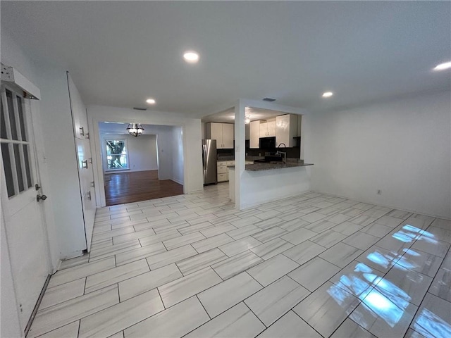 unfurnished room featuring light hardwood / wood-style flooring and a notable chandelier