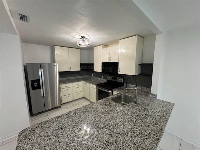 kitchen featuring kitchen peninsula, dark stone countertops, stainless steel appliances, and sink