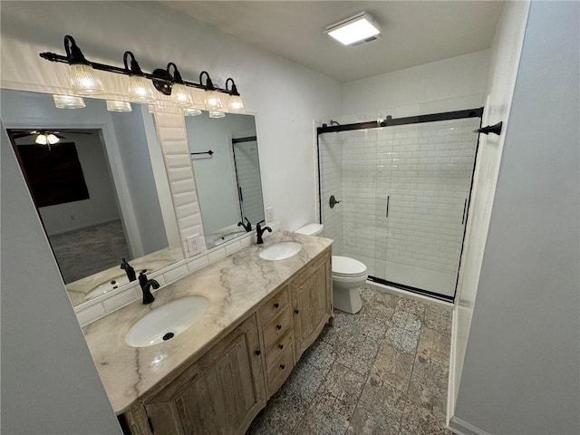 bathroom featuring vanity, toilet, and a shower with door