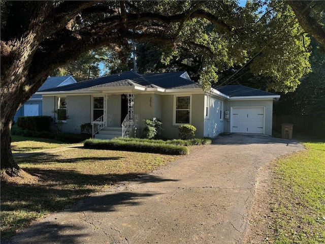 single story home featuring a porch, a front yard, and a garage