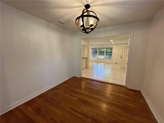 unfurnished dining area featuring a chandelier and dark hardwood / wood-style flooring