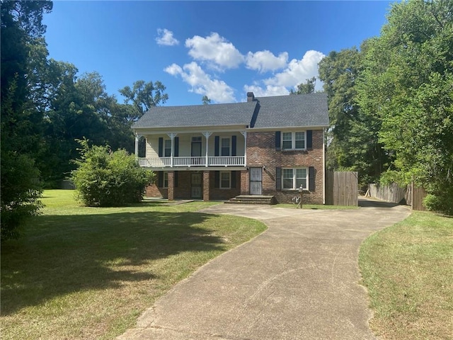 view of front facade featuring a balcony and a front lawn