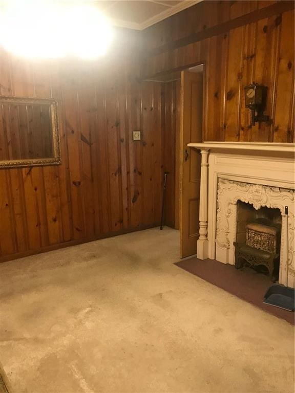 basement featuring wooden walls, light carpet, and a fireplace