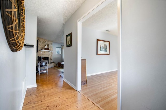 hall featuring wood-type flooring and a textured ceiling