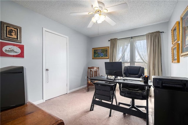 home office with ceiling fan, carpet floors, and a textured ceiling