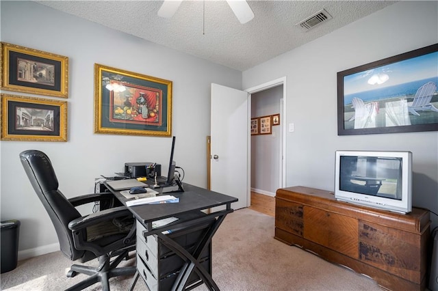 office area with ceiling fan, light colored carpet, and a textured ceiling