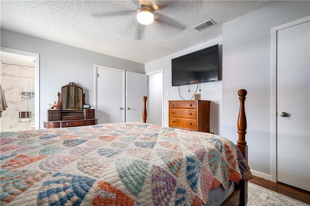 bedroom with hardwood / wood-style floors, ensuite bath, a textured ceiling, and ceiling fan