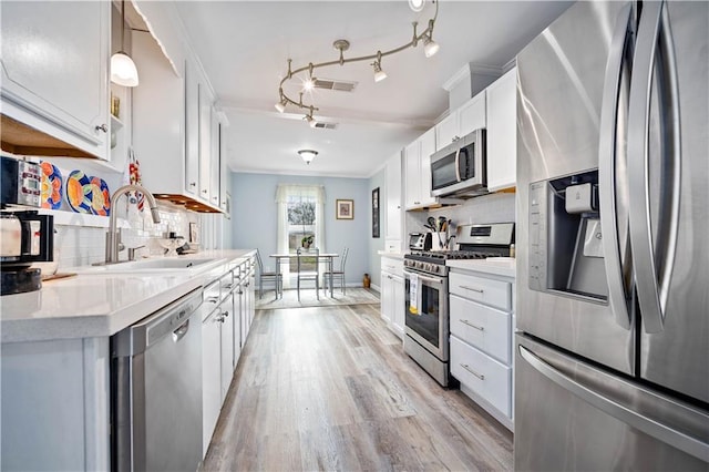 kitchen featuring white cabinetry, stainless steel appliances, light hardwood / wood-style floors, and sink