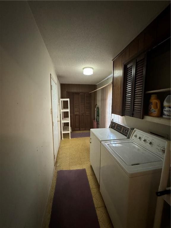 clothes washing area featuring washer and clothes dryer and a textured ceiling