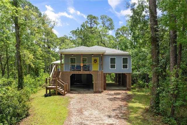 911 Lockenbie Pl, Dauphin Island, AL 36528 - coastal inspired home with a carport, ceiling fan, stairway, dirt driveway, and a front yard