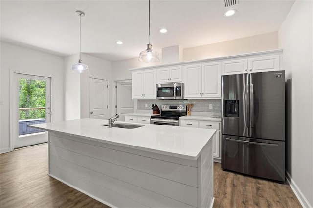 911 Lockenbie Pl, Dauphin Island, AL 36528 - kitchen featuring stainless steel appliances, white cabinets, light countertops, backsplash, and a center island with sink