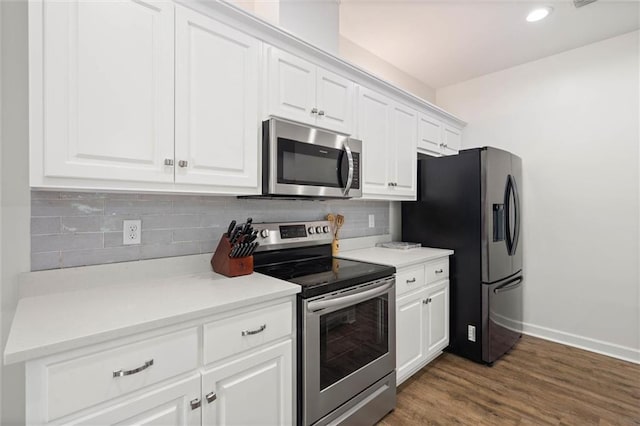 911 Lockenbie Pl, Dauphin Island, AL 36528 - kitchen featuring appliances with stainless steel finishes, white cabinets, backsplash, dark wood-type flooring, and recessed lighting