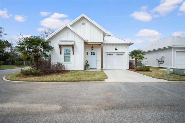 modern farmhouse with central AC, board and batten siding, concrete driveway, a front yard, and a garage