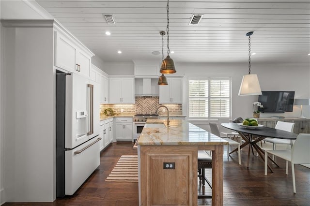 kitchen featuring visible vents, backsplash, high quality appliances, dark wood-style floors, and a kitchen island with sink