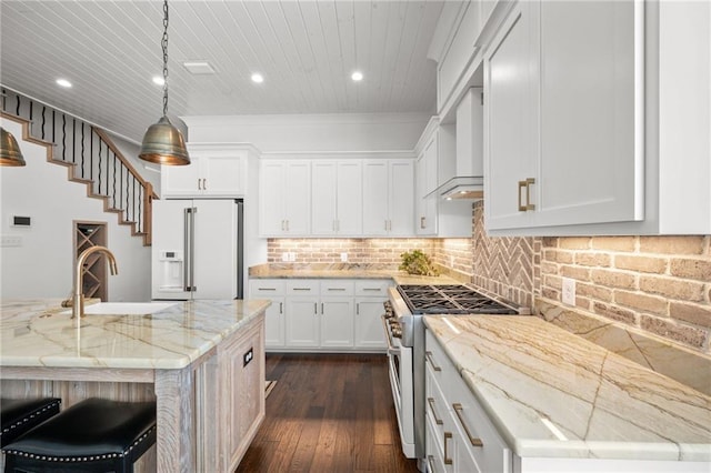 kitchen with stainless steel range, a sink, white fridge with ice dispenser, wall chimney exhaust hood, and decorative backsplash