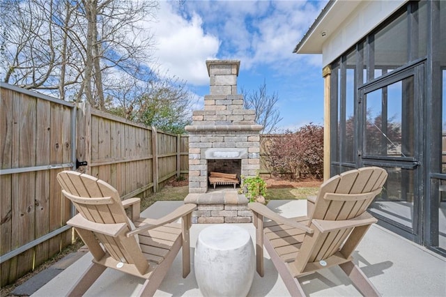 view of patio with a fenced backyard and an outdoor stone fireplace