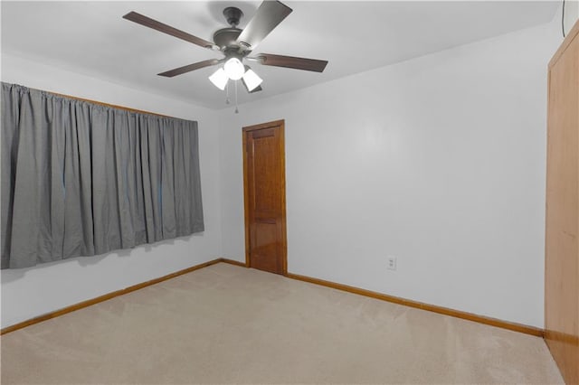 carpeted spare room with ceiling fan