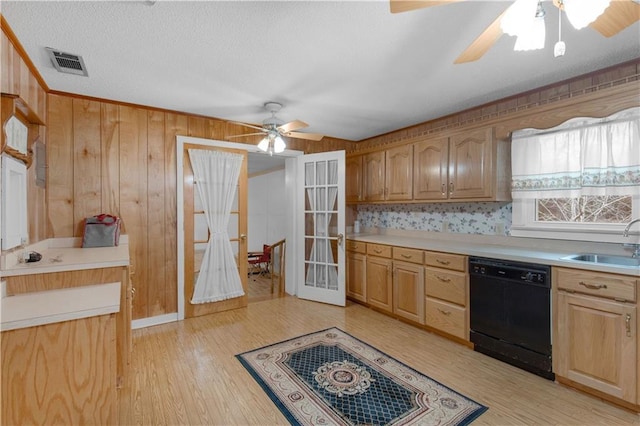 kitchen with black dishwasher, sink, light brown cabinetry, and light hardwood / wood-style flooring