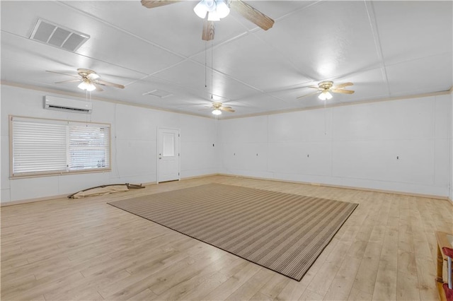 unfurnished room with ceiling fan, a wall mounted AC, and light hardwood / wood-style floors