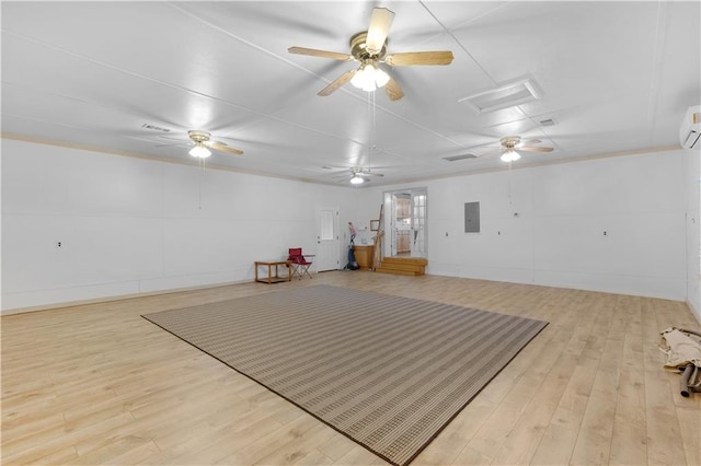 miscellaneous room featuring a wall mounted air conditioner, electric panel, ceiling fan, and light hardwood / wood-style flooring